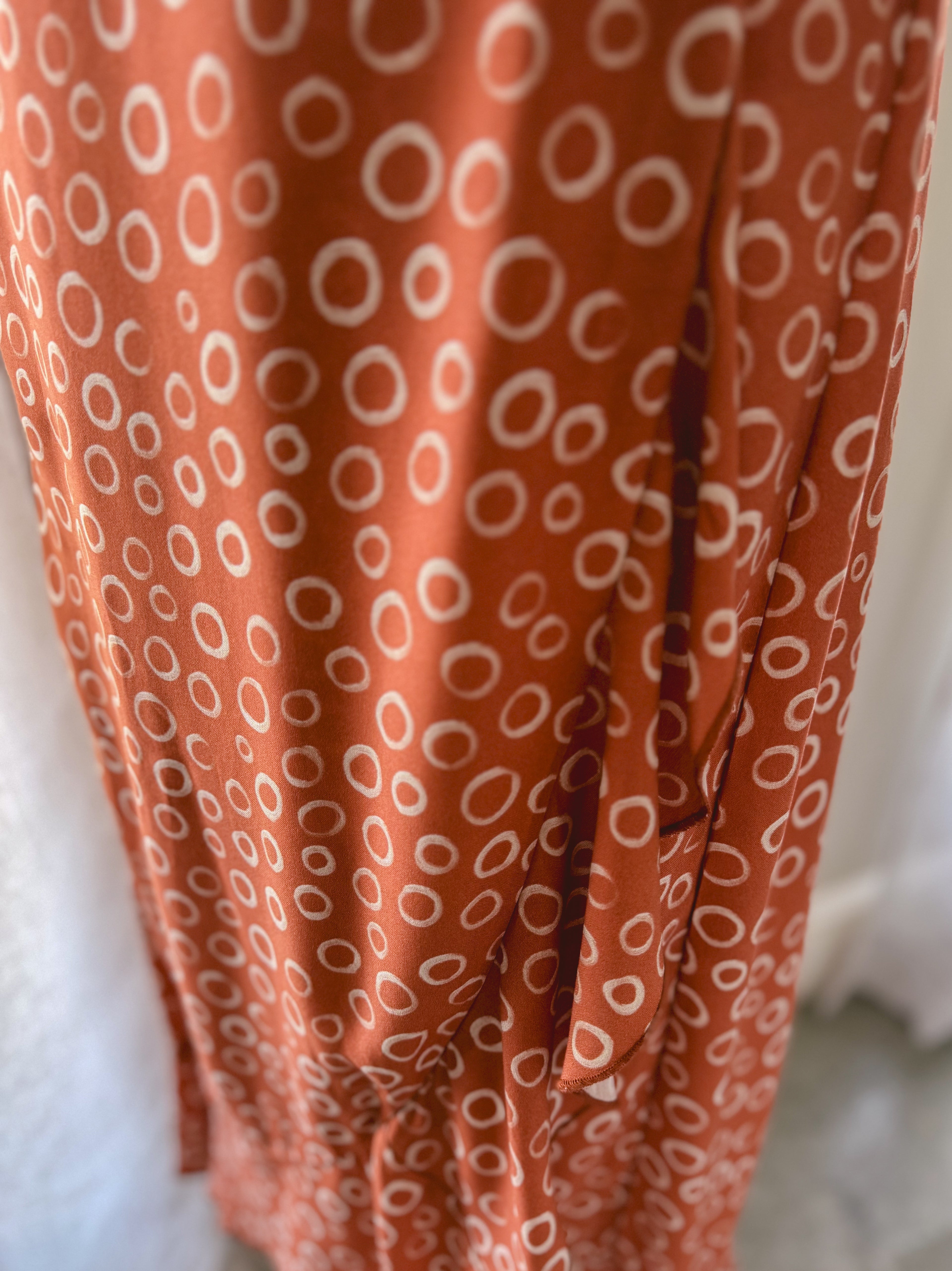 Close-up of a rusty brown Ecovero Viscose fabric with white circular pattern.