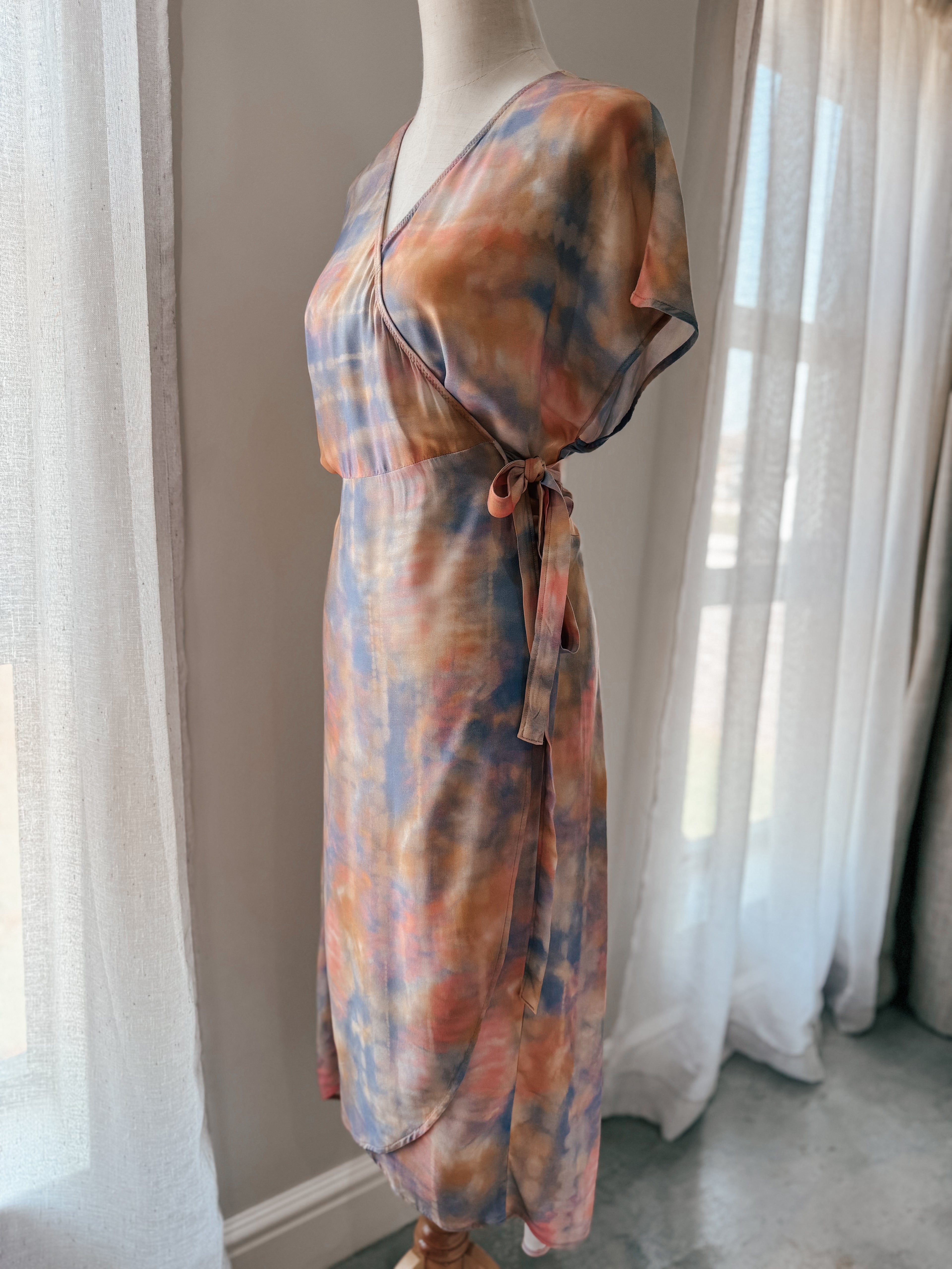 Tie-dye style print midi wrap dress made from ecovero viscose fabric in soft watercolour hues with relaxed grown on cap sleeve.
