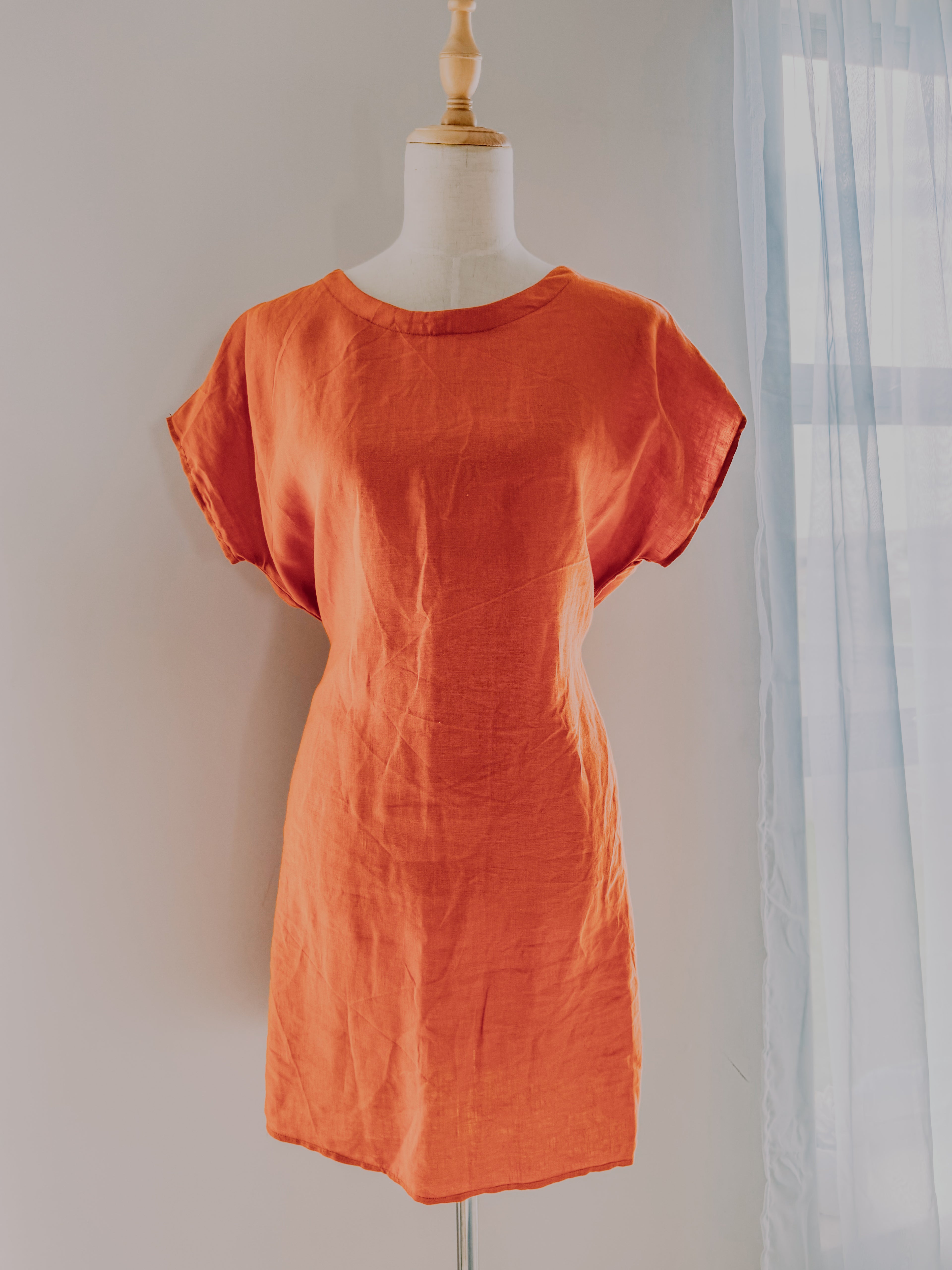 Pure linen tunic dress in a orange colour on a mannequin.