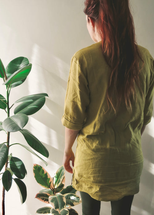 Back view of person wearing avo green linen kaftan in above knee length with three-quarter sleeves.