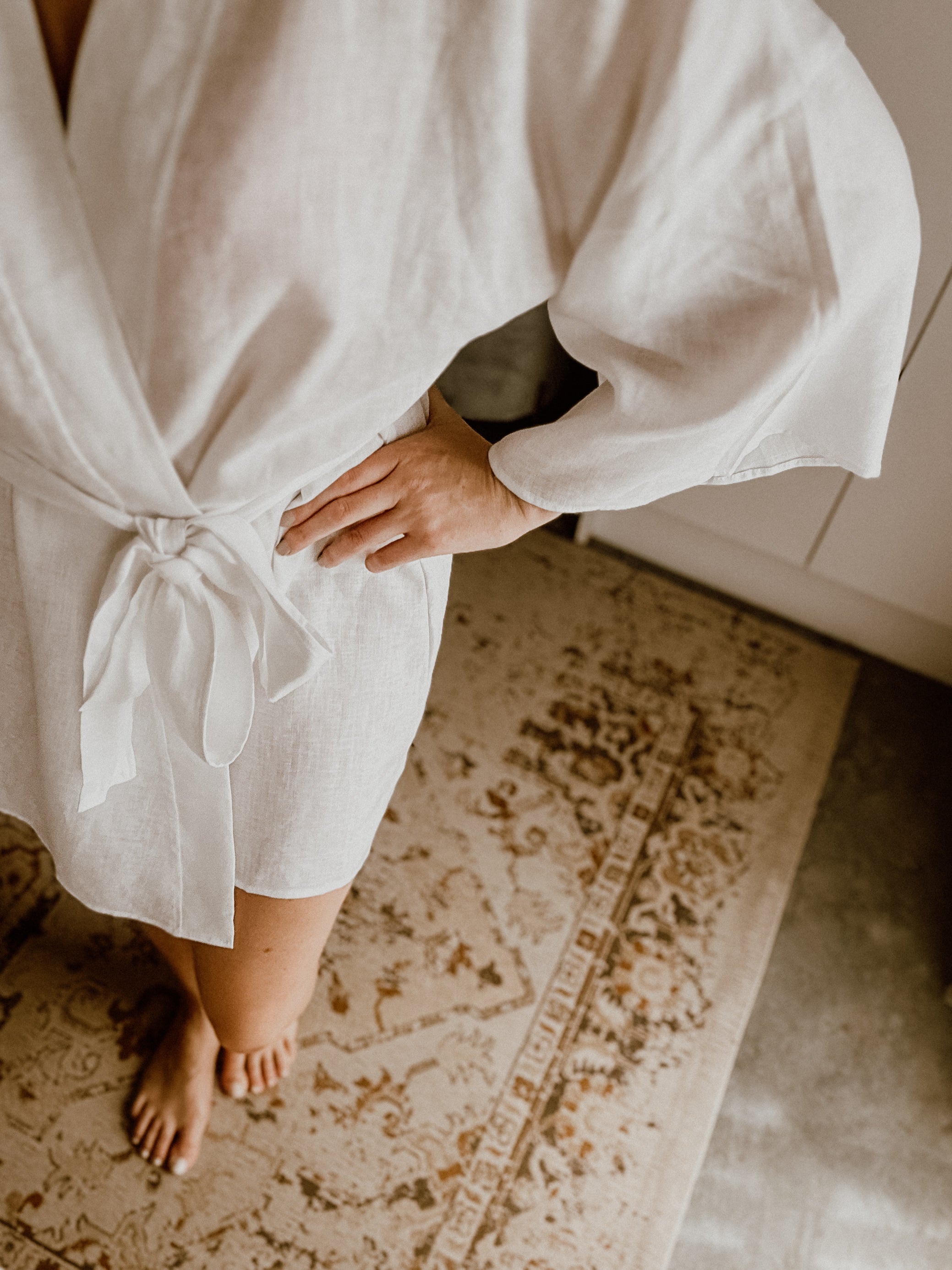 Person wearing a white linen robe after a morning shower.