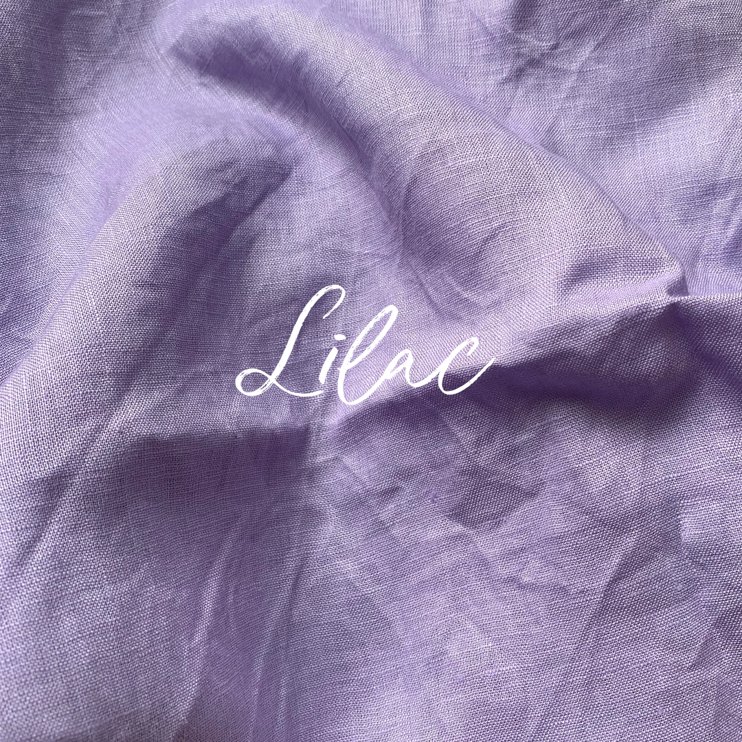 Close-up of lilac pure linen fabric with the word 'Lilac' written on it.