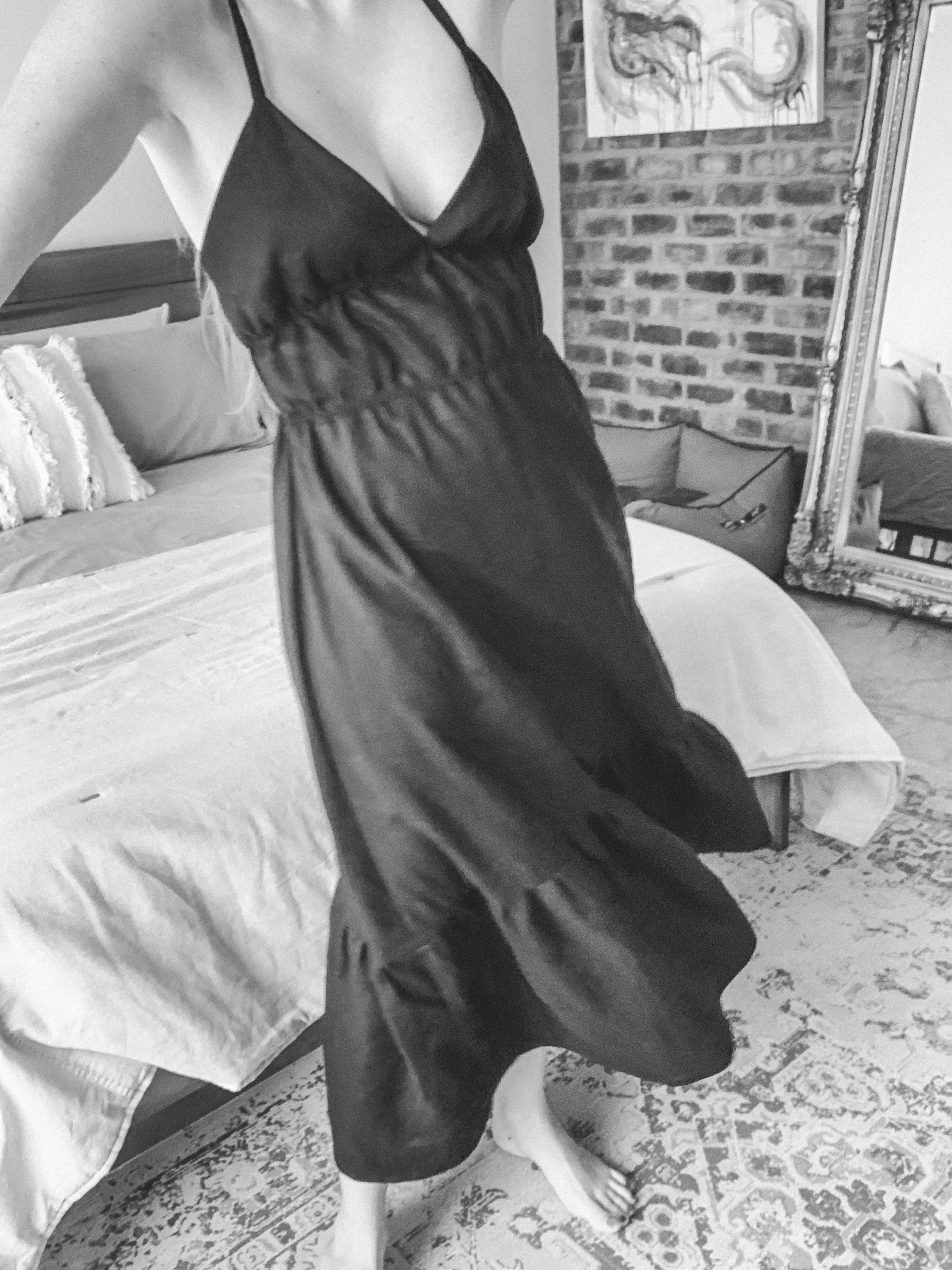 Person wearing a black linen maxi dress, showing how it drapes in movement.