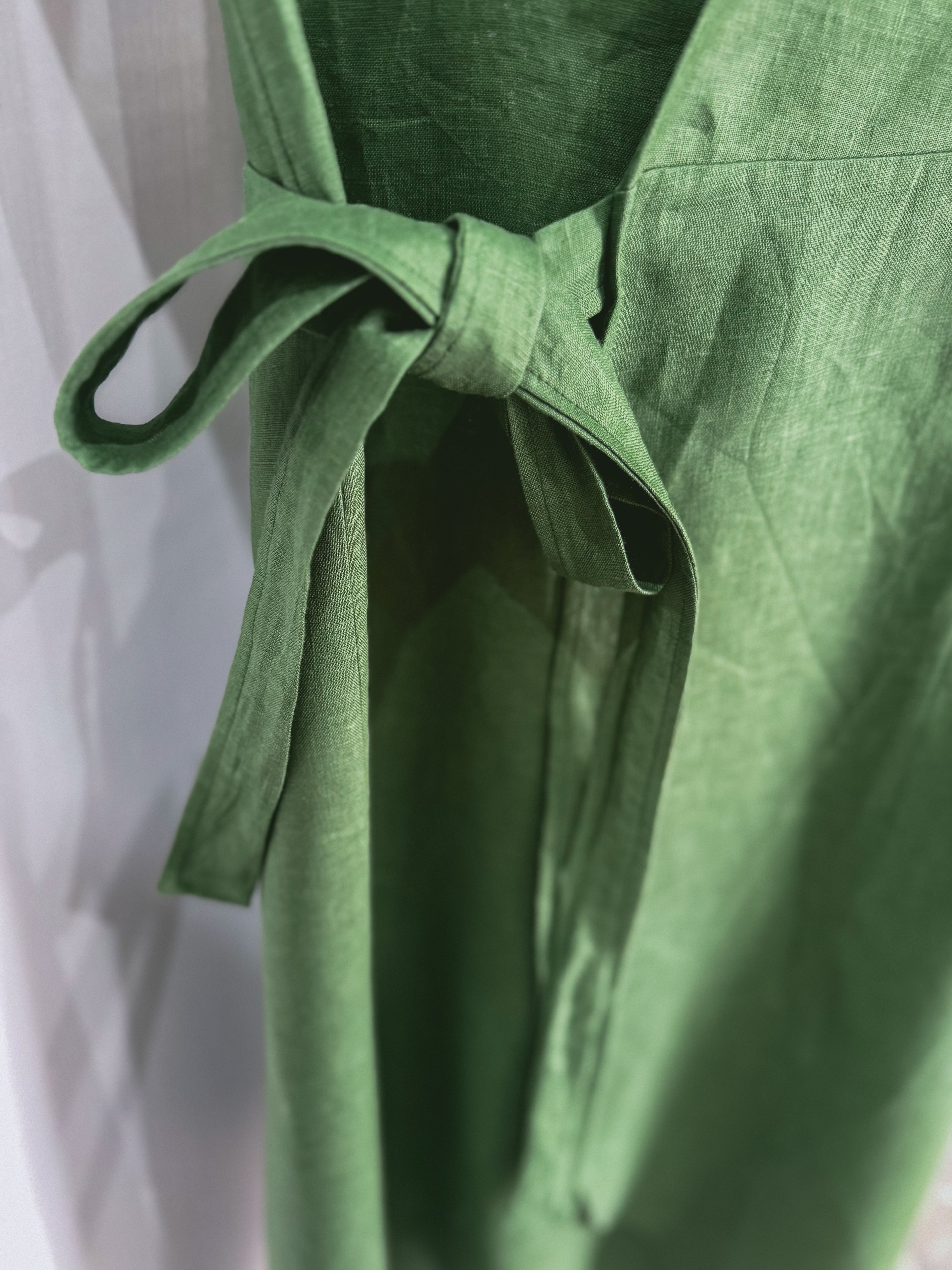 Green linen dress with a side tie detail.