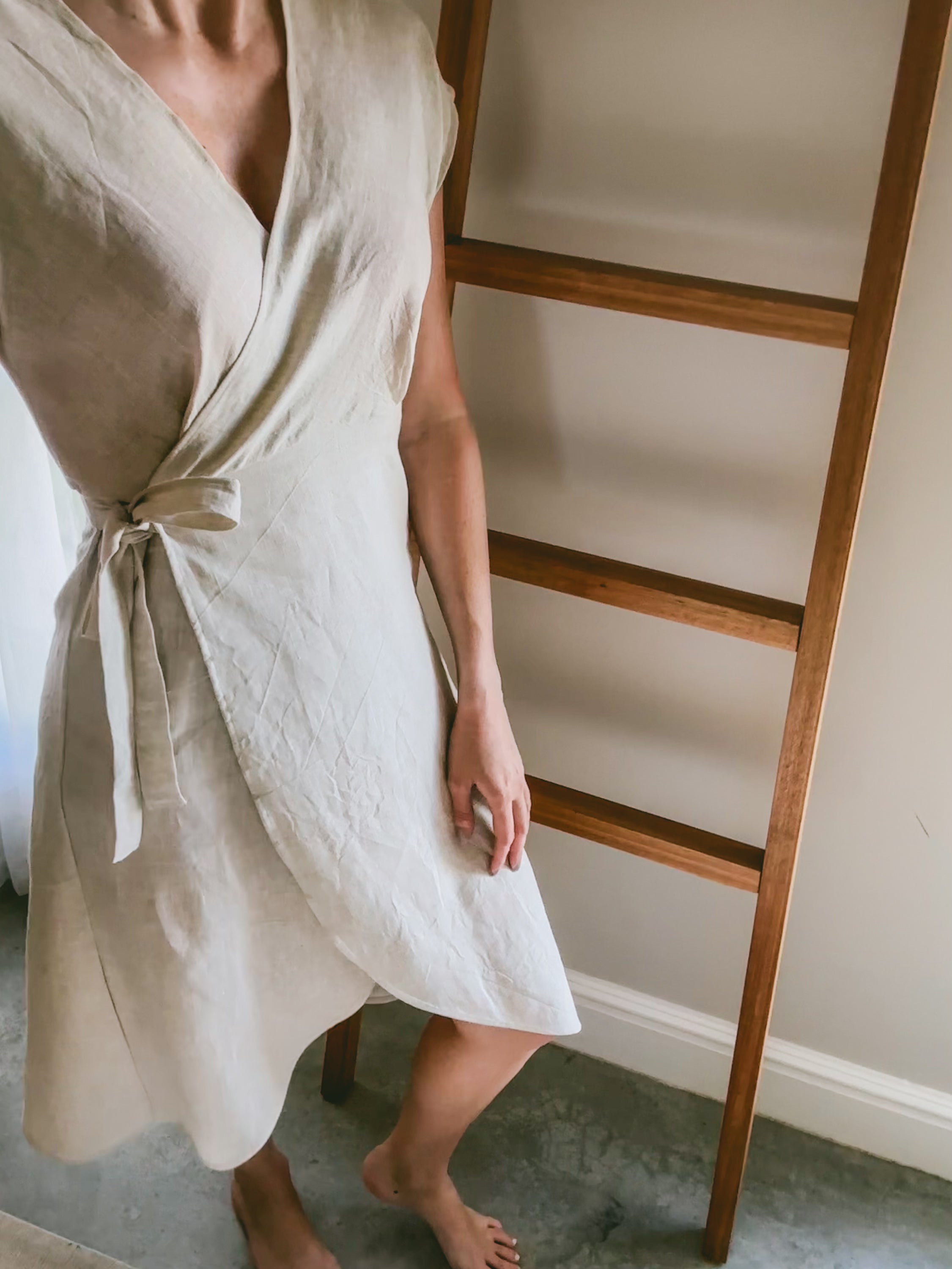 Person wearing a beige pure linen dress with side tie.