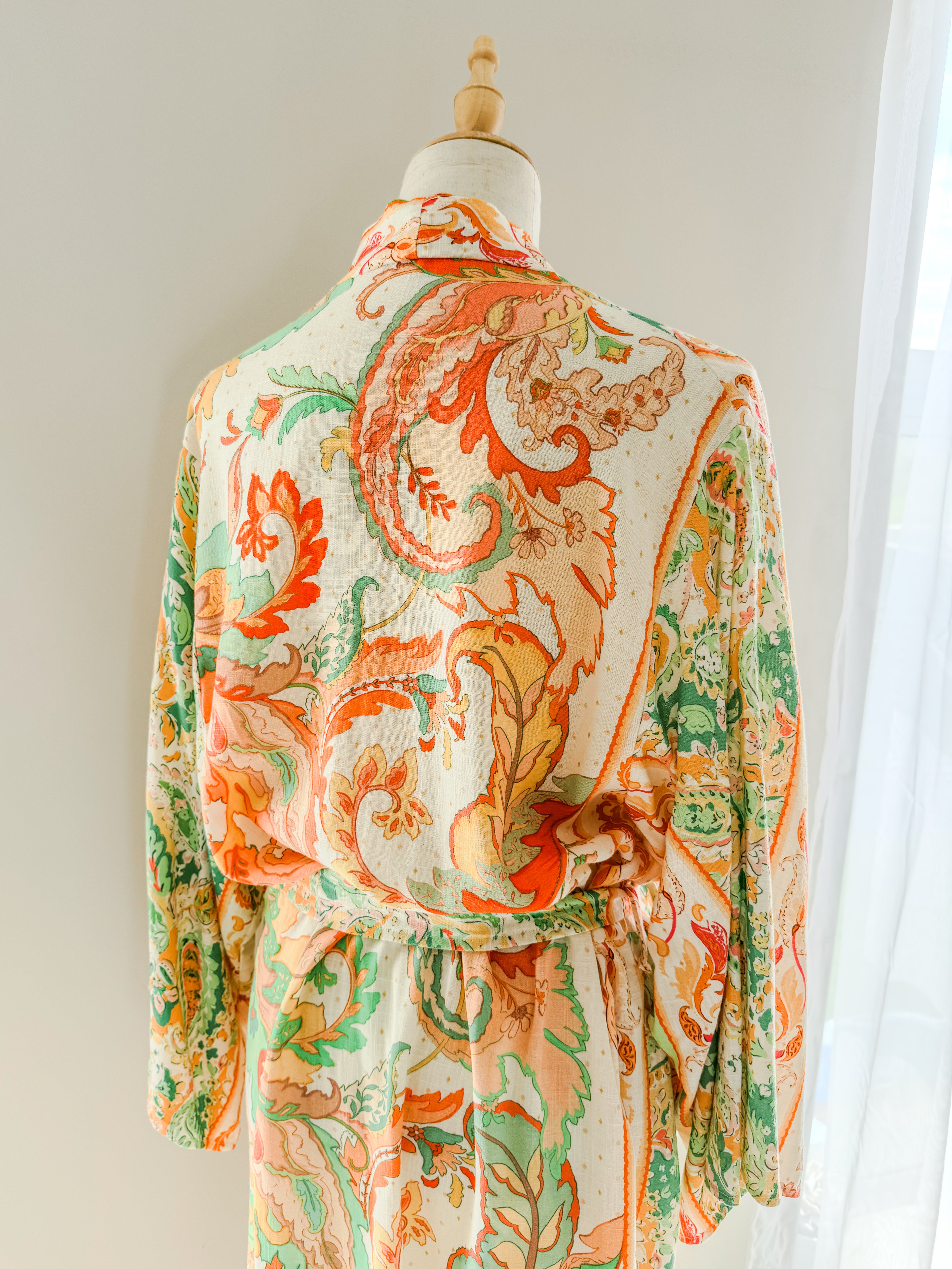 Back view of colourful paisley patterned kimono gown on a mannequin.