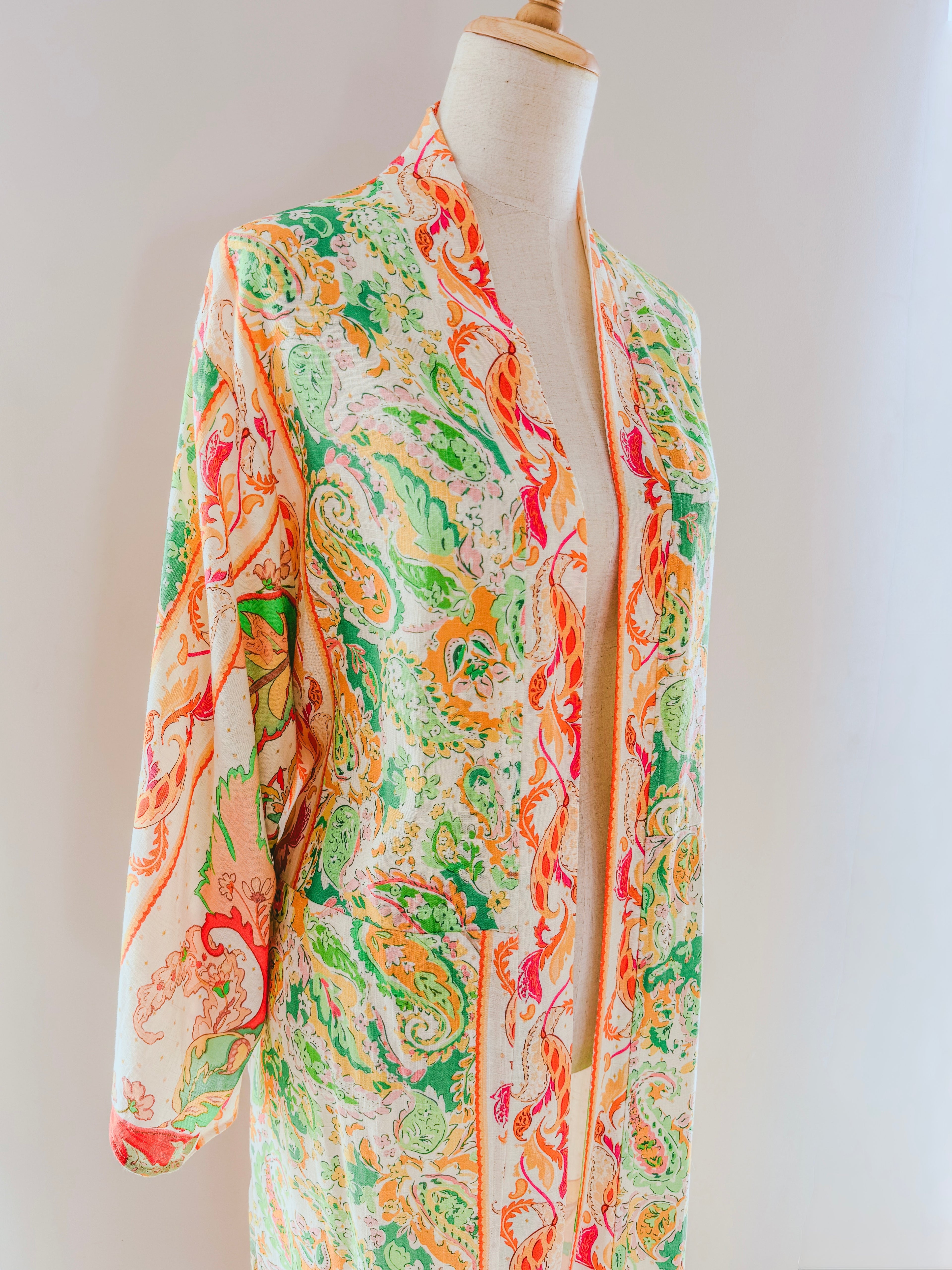 Colourful paisley patterned kimono gown hanging open on a mannequin.