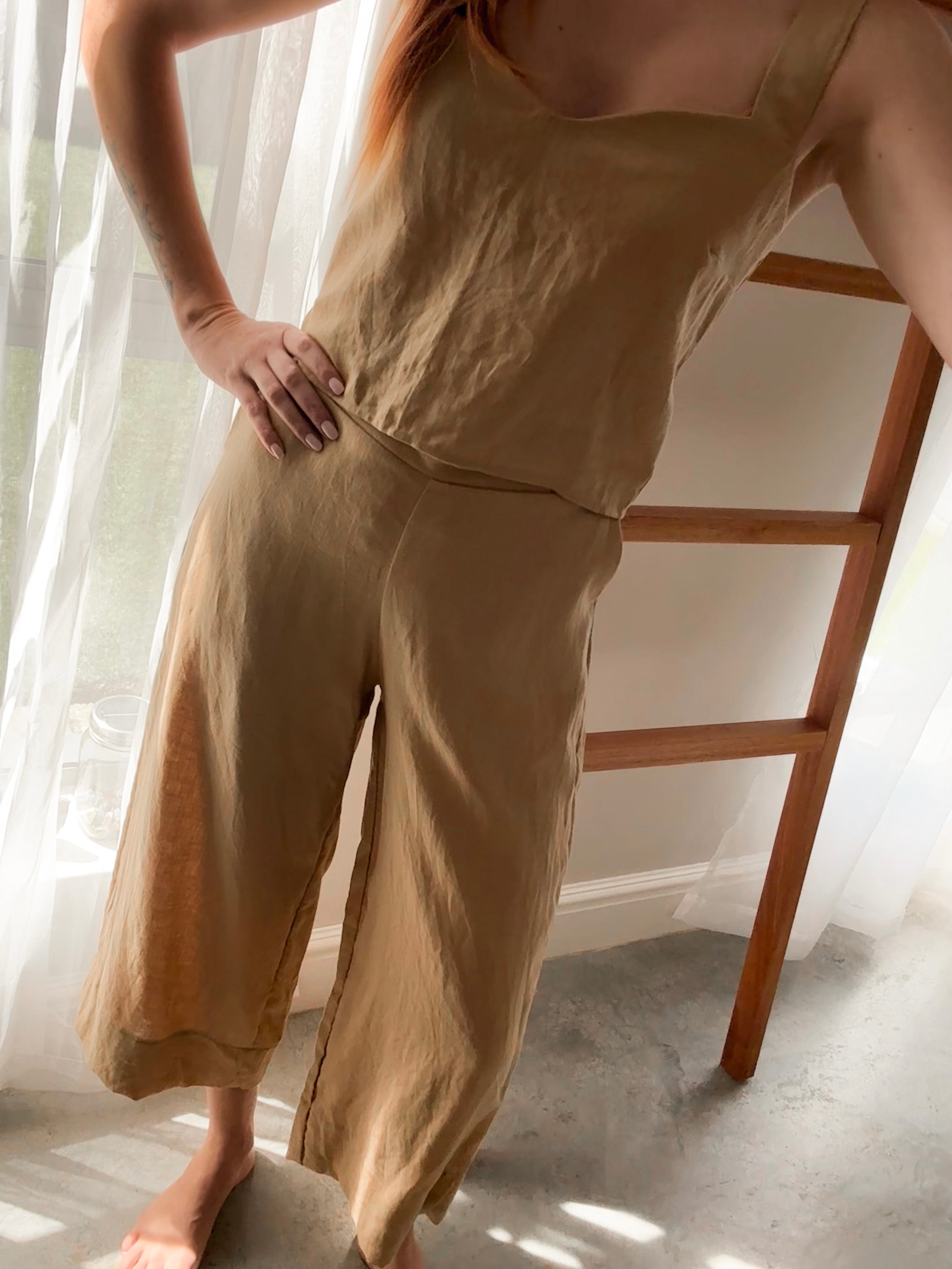 Person wearing a beige pure linen outfit standing in a room with natural morning light.