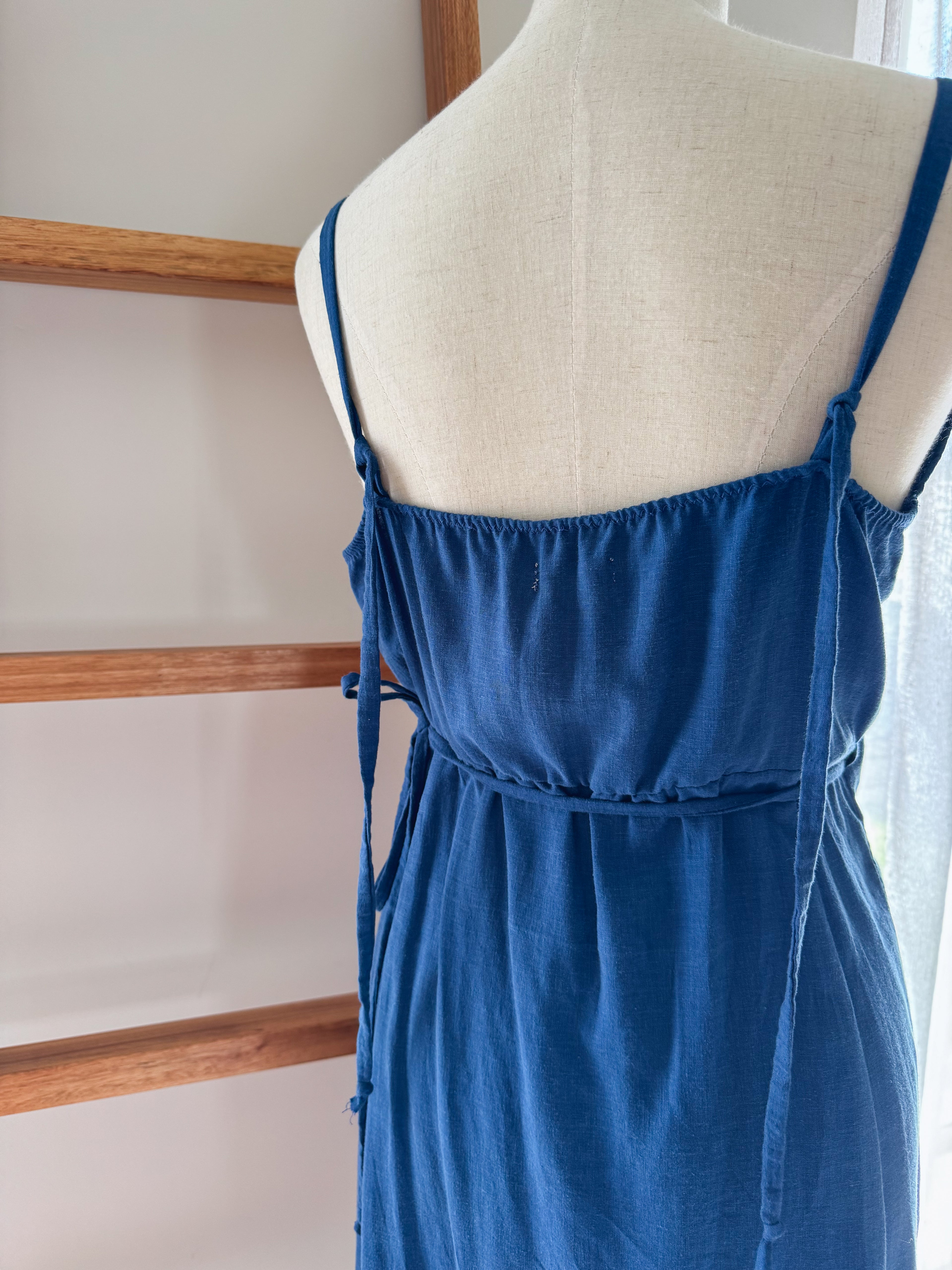 Blue dress on a mannequin showing the back view of adjustable straps.
