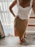 Person wearing a white pure linen sleeveless crop length top with trending square semi-princess neckline.