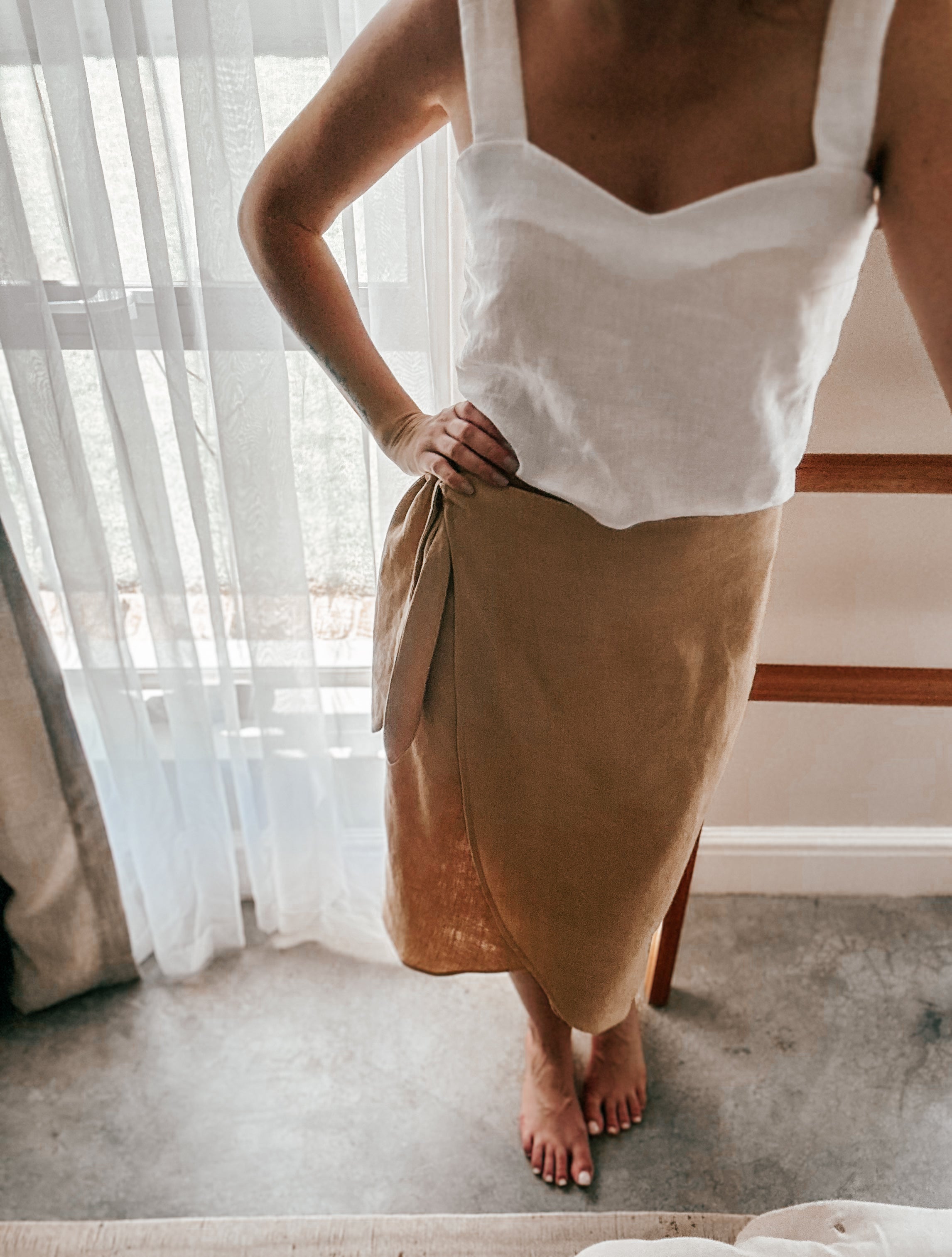 Person wearing a white pure linen sleeveless crop length top with trending square semi-princess neckline.